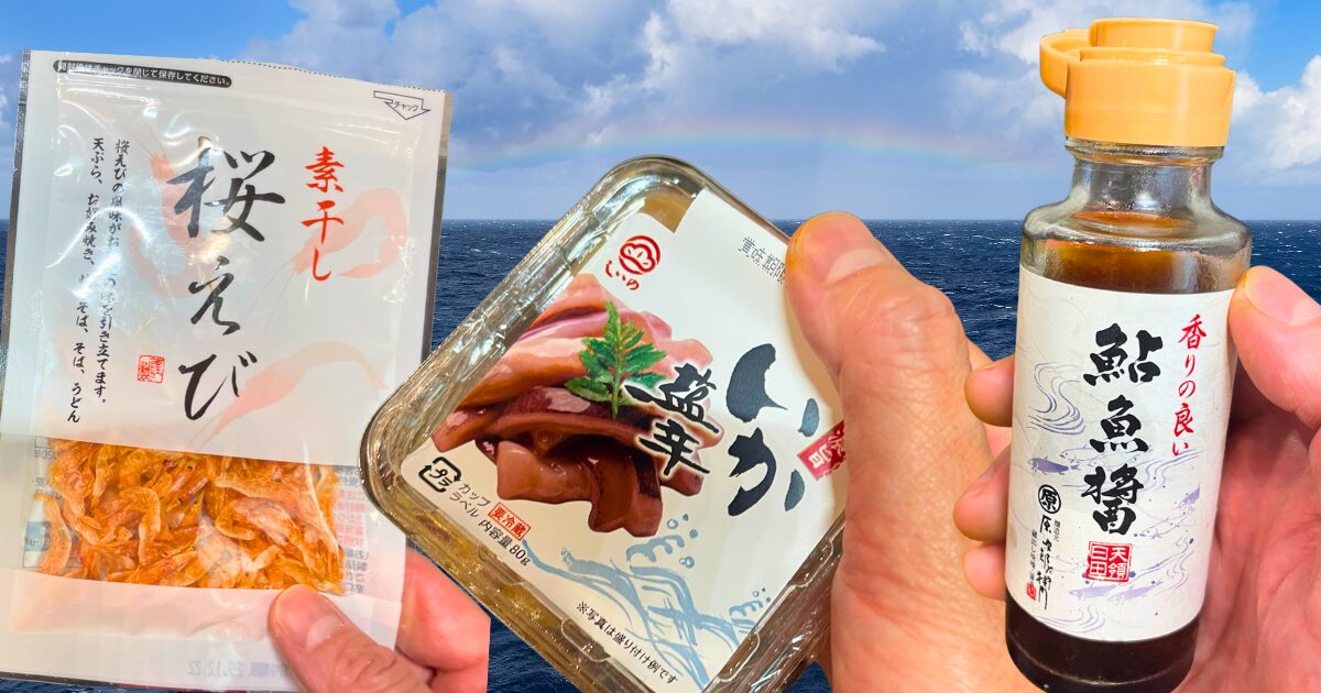 桜えび・いかの塩辛・鮎の魚醤のパッケージを手に持った魚介トリオの素材写真