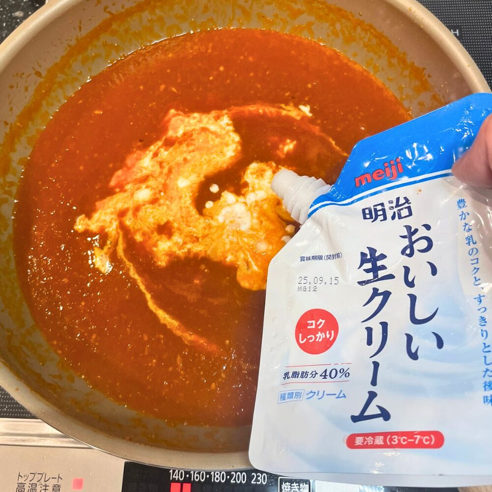 煮込んだトマトと海老出汁のソースに、生クリーム400mlと牛乳200mlを注ぎ入れる工程。弱火で5分温め、沸騰させずにまろやかさをプラスしてビスクのベースを完成させる。