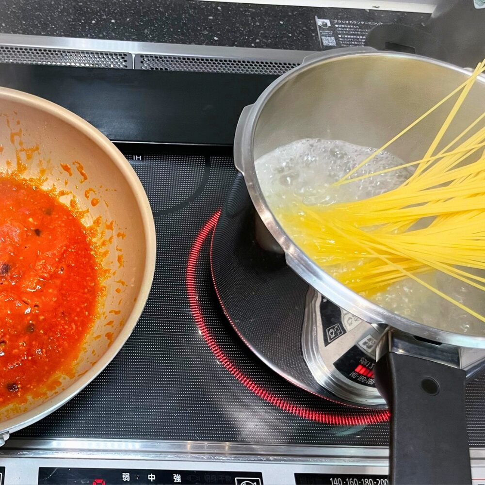 別茹で版アラビアータの調理工程。左のフライパンではトマトソースを煮詰め、右の鍋ではスパゲッティを1%の塩を加えた湯で茹でている様子
