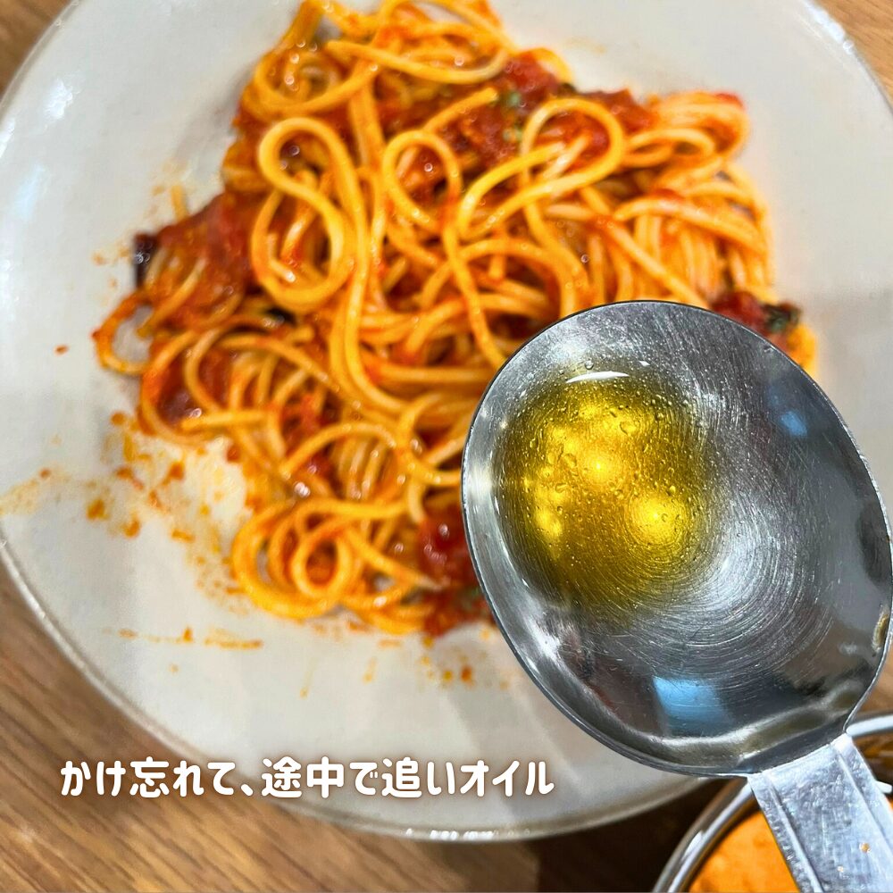 仕上げにスプーンでエビオイルを回しかけて香りをプラスするアラビアータ