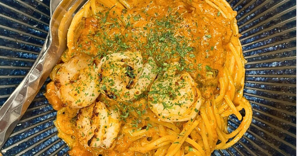 フライパンひとつで仕上げたワンパン海老ビスク風パスタ。プリっとしたエビと濃厚ソースが麺に絡み、仕上げにパセリを散らした完成品。