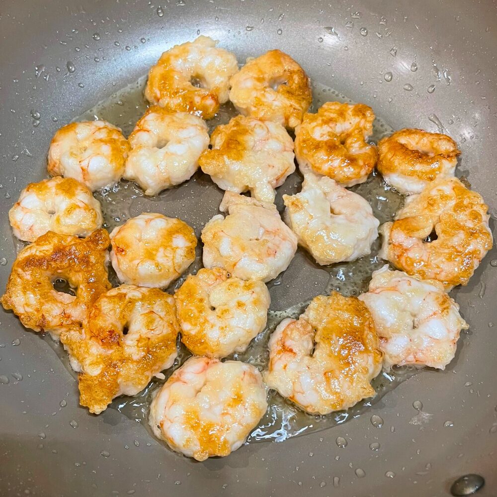 フライパンで赤エビを両面こんがり焼いた揚げ焼き工程。卵白と片栗粉の衣が香ばしく色づき、少ない油でもカリッと仕上がっている。